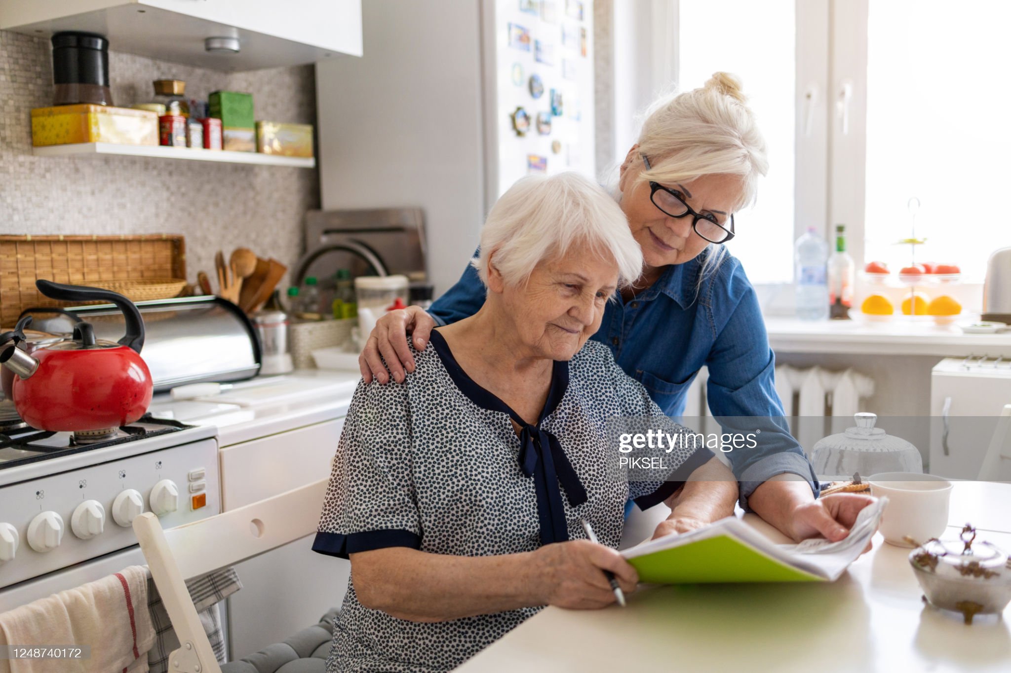 Mature woman helping elderly mother with paperwork